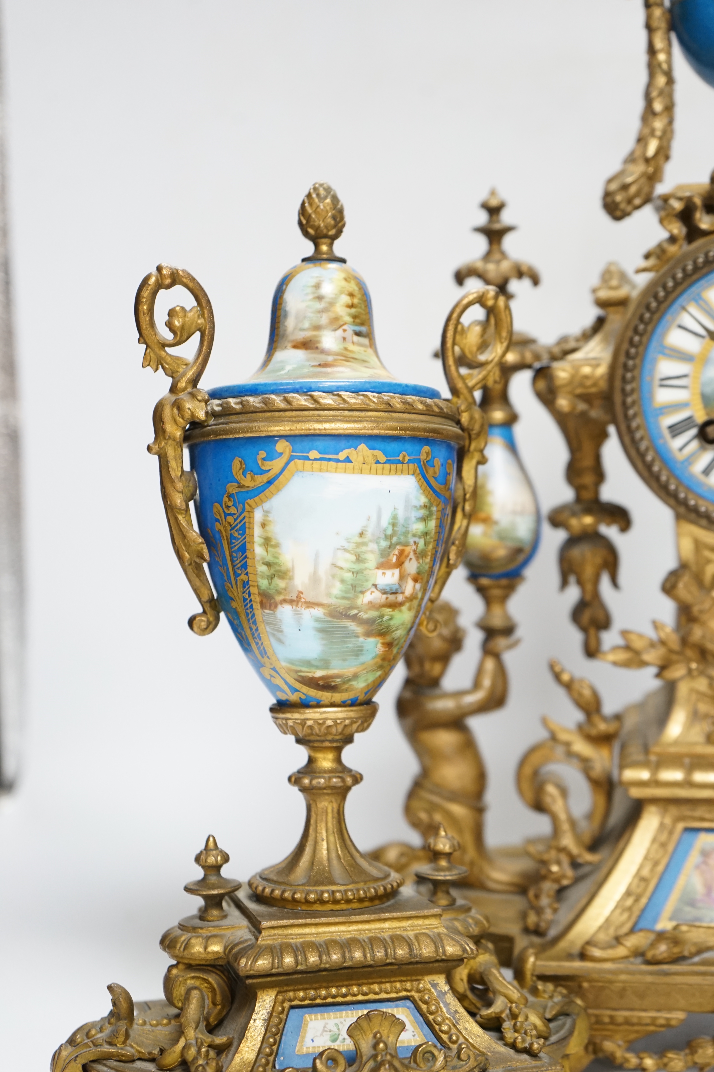 A Sevres style porcelain and gilt metal clock garniture, 44cm high